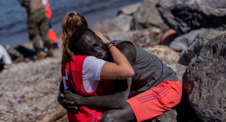Voluntaria de Cruz Roja consuela a migrante