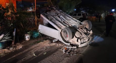 Auto vuelca y cae sobre vivienda