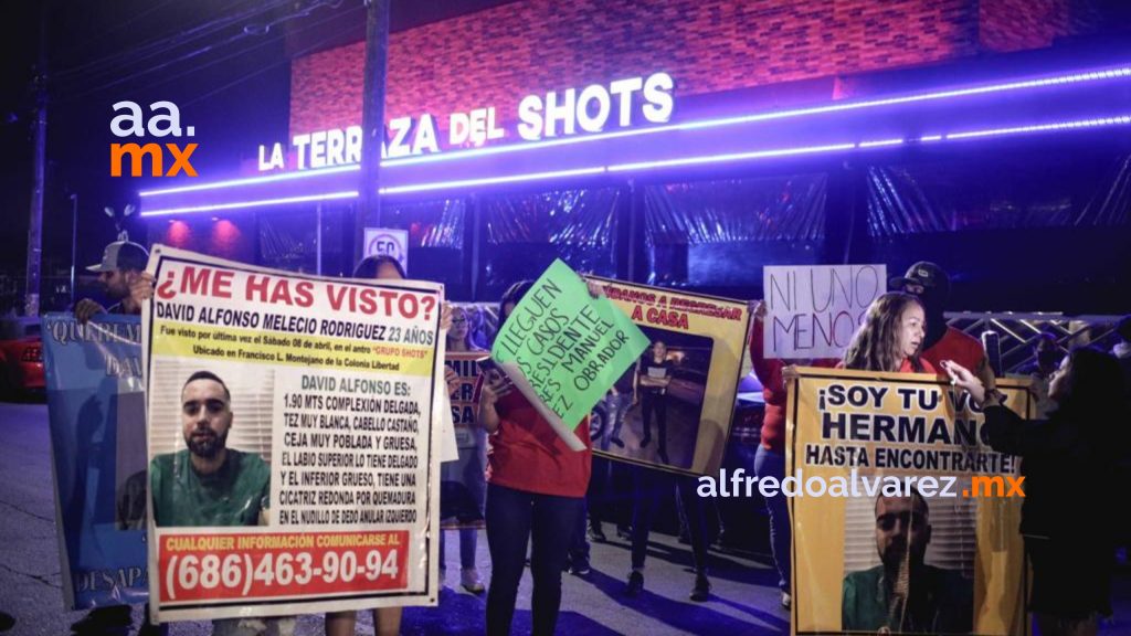 Familias-desaparecidos-manifiestan-bares-Mexicali MEXICALI.- Encabezados por la familia de 'David Alfonso Melecio' (desaparecido), se llevaba a cabo una manifestación frente a las instalaciones del SHOTS: "Que el gobierno haga algo por nuestros desaparecidos", dice la convocaría. Elementos de la Fiscalía General del Estado catearon dentro del bar y cerraron el paso vehicular, además delimitar la zona para los asistentes a la manifestación. Posteriormente, los manifestantes lograron cerrar el Bar Copeo pues aseguraban era una burla que estuviera abierto luego de la desapariciones de jóvenes en esa zona de bares que ya han denominado “el triángulo de las Bermudas”. El pasado 8 de abril tres hombres fueron desaparecidos en un bar de Mexicali, situación que no es un hecho aislado por lo que las críticas a la Fiscalía y a la Policía municipal no se hicieron esperar, pues se considera que poco se hace ante las desapariciones de hombres en ese con historial negativo en tema de desaparecidos. Cabe resaltar que la madrugada del miércoles pasado, la Dirección de Seguridad Pública de Mexicali, además de agentes de la fiscalía realizaron una inspección a 8 antros de la zona, dando como resultado la detención de 2 hombres con armas de fuego.